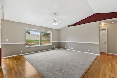 Empty room with vaulted ceiling, light wood-type flooring, and a ceiling fan