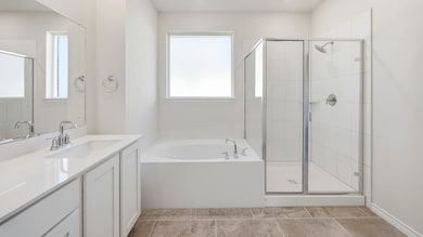 Bathroom featuring a garden tub, vanity, a shower stall, and light tile patterned flooring