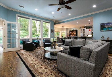 Open floor plan, hardwood floors and full windows look out onto the wooded back yard.