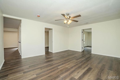 Unfurnished room with dark wood-type flooring, a textured ceiling, and a ceiling fan