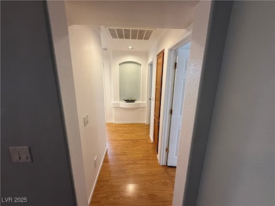 Hall featuring light wood finished floors, baseboa
