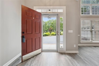 Entrance foyer with baseboards and light wood-type flooring