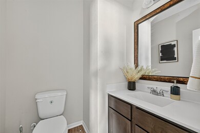 This bathroom features a modern design with a sleek vanity and large mirror. There's a decorative plant and artwork adding a touch of style. The neutral color scheme creates a clean and inviting atmosphere.
