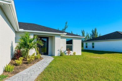 Back of property with a lawn, stucco siding, and roof with shingles