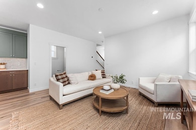 Living room featuring light wood-style flooring, stairway, and recessed lighting