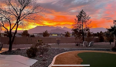 Yard at dusk with a patio, a mountain view, and a putting area