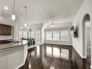 Kitchen featuring dark stone counters, sink, dark 