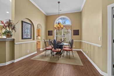 Dining area with dark wood-style flooring, a chand
