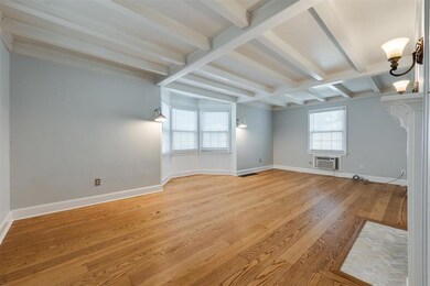 Spare room featuring beamed ceiling, light wood-ty