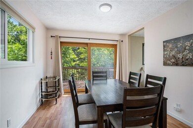 Dining space featuring plenty of natural light, light wood-style flooring, and a textured ceiling