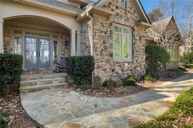 Entrance to property with stone siding, a shingled