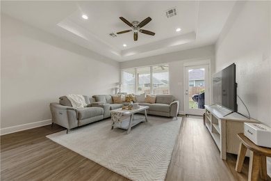 Living area featuring a ceiling fan, wood finished