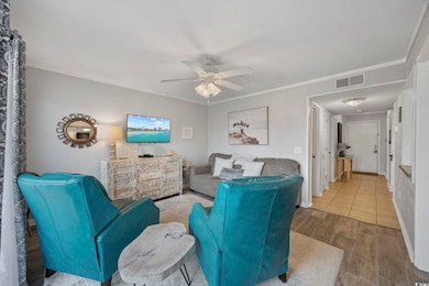 Living area featuring ornamental molding, wood finished floors, and a ceiling fan