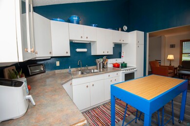 Kitchen with sink, white cabinetry, and white elec