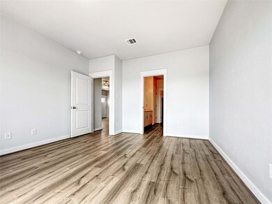 Unfurnished bedroom with wood finished floors, ba