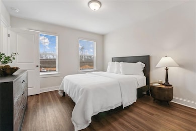 Bedroom with dark hardwood / wood-style floors