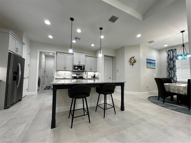 Kitchen featuring fridge, an island with sink, gra