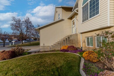 View of side of home with a yard, brick siding, and stairway