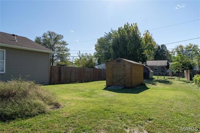 Fenced backyard featuring a storage shed