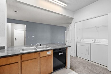 Kitchen featuring washer and dryer, a textured cei