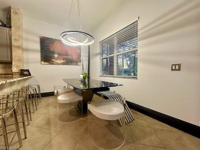 Dining space with light tile patterned floors and a chandelier