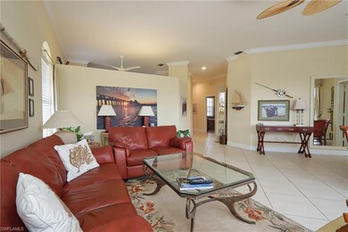 Living area with ceiling fan, ornamental molding, and light tile patterned floors