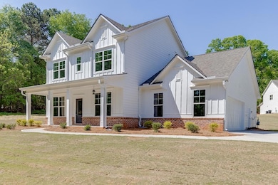 Modern farmhouse featuring a front lawn, driveway,