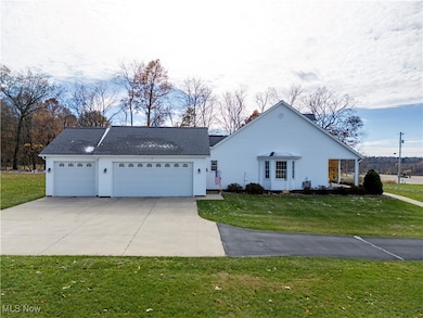 Ranch-style house featuring driveway, a garage, and a front yard