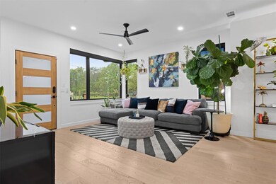 Living room with a ceiling fan, light wood-style 