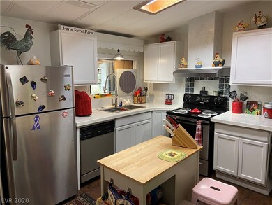 Kitchen, featuring (2017) Cabinets, Tile Countertops, hood range, stove, dishwasher, disposal, sink/faucet, refrig, and mobile butcher block island.