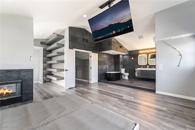 Unfurnished living room with light wood-type flooring, a multi sided fireplace, and recessed lighting