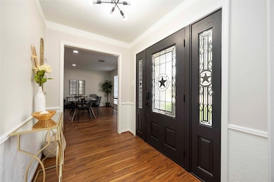 A striking hardwood door opens to a generous foyer