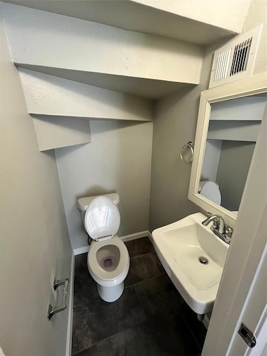 Half bath with toilet and baseboards