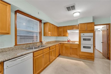 Double Stainless Steel sinks, Gas Cooktop, Dishwasher, and Double Oven. Ample prep space for the home cook.