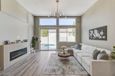 Living area with wood finished floors, a chandelie