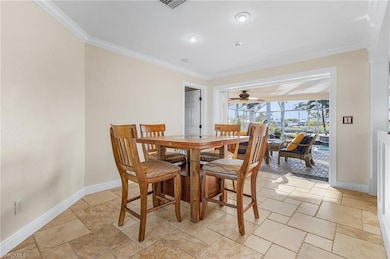 Dining area featuring ceiling fan and crown moldin