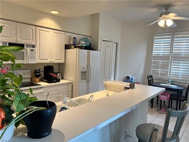 Kitchen with light tile, white appliances, light c