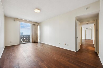 Empty room with dark wood-style floors and basebo