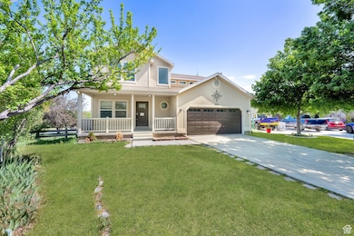 View of front of home featuring a porch, driveway, an attached garage, and a front lawn