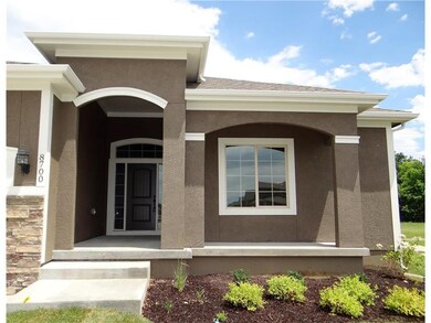 Front entry with covered porch and pretty landscap
