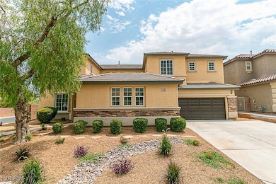 View of front facade featuring stone siding, stucco siding, driveway, and a garage