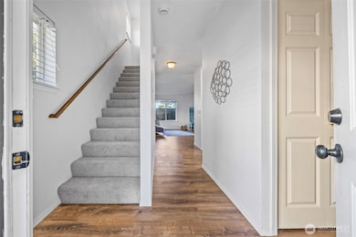 The inviting entry captures the relaxed pace of Whidbey Island living. New carpet (2025) and natural light guide you upstairs to private bedroom retreats.