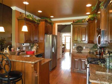 Kitchen: 12 x 11Upgraded stainless appliance package, with 5 burner gas range, crown molding, hardwood flooring, granite counter tops, solid maple cabinets,  recessed lighting, breakfast bar w/ pendant lighting, and tiled backsplash   