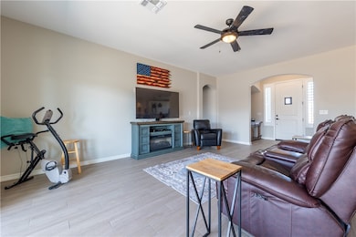 Living area with arched walkways, a ceiling fan, l