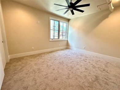 Unfurnished room featuring a ceiling fan and light