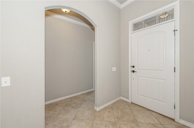 Entryway featuring crown molding, arched walkways,