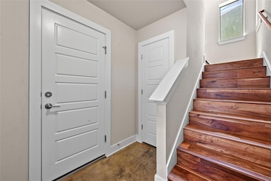 Staircase featuring concrete flooring and baseboa