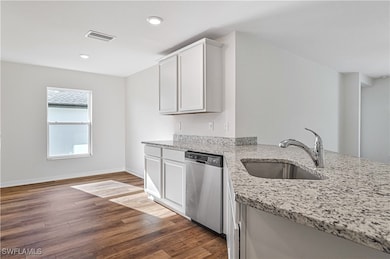 Kitchen featuring stainless steel dishwasher, wood