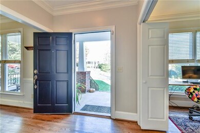 Foyer with crown molding and hardwood floors.