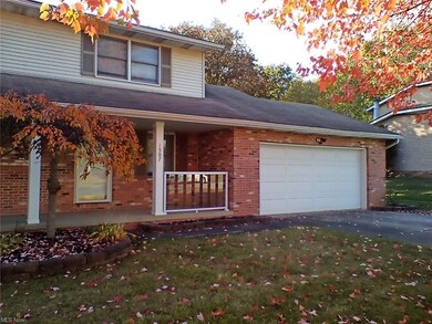 View of front facade featuring a porch, a garage, and a front lawn